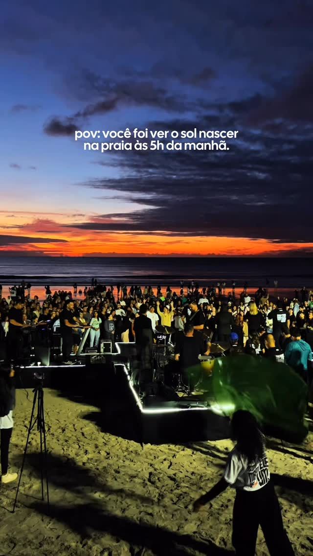 Multidão reunida ao amanhecer na praia